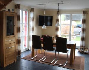 a dining room with a table and four chairs at Fischer's Ferienhaus Rügen mit Sauna und Kamin in Ummanz