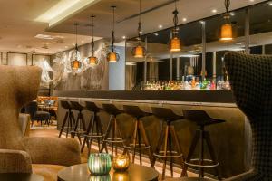 a bar in a restaurant with stools at Motel One Manchester-Royal Exchange in Manchester