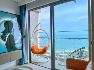a room with a balcony with a view of the ocean at Căn hô The Song Du lịch Biển Tháp Tam Thắng Infinity Pool - Sophia Home in Vung Tau