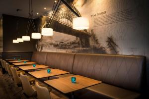 a row of tables in a restaurant with lights at Motel One Newcastle in Newcastle upon Tyne +26 photos