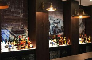 a bar with two windows with bottles of alcohol at Motel One Newcastle in Newcastle upon Tyne