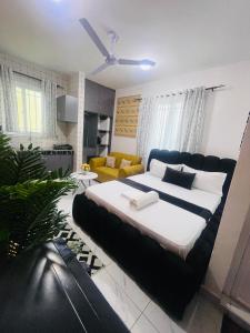 a bedroom with a large bed and a living room at Mo Homes studio in Mombasa