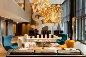 a living room with a couch and chairs at Motel One Warsaw-Chopin in Warsaw