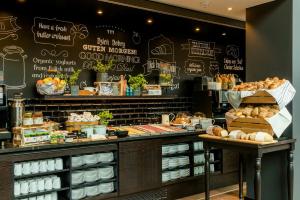 a bakery with a counter with bread and pastries at Motel One Warsaw-Chopin in Warsaw