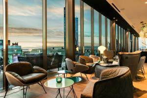 a hotel lobby with chairs and tables and windows at Motel One Leipzig-Post in Leipzig