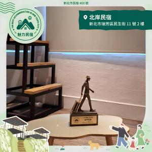 a statue of a man walking on a box at North Coast Homestay in Ruifang +3 photos