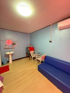 a living room with a blue couch and a table at KohLibong Beach House Homestay in Ban Batubute