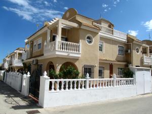 una casa grande con una valla blanca delante de ella en Sol Beach 24, en Playas de Orihuela