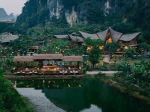 a resort with a pond in front of it at Lamia Bamboo Retreat Ninh Binh in Ninh Binh