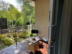 a porch with a table and chairs on a deck at SIGNAL BOX Short Stay in Gembrook