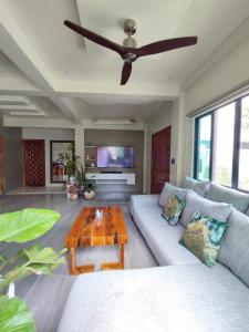 a living room with a couch and a ceiling fan at Shella Home Stay in Miagao
