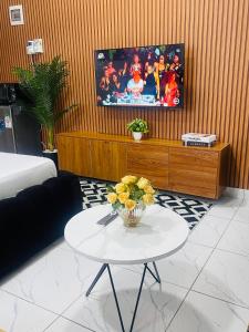 a living room with a table and a tv at Mo Homes studio in Mombasa