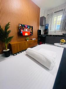 a bedroom with a bed with a tv on the wall at Mo Homes studio in Mombasa +1 photo