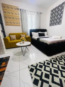 a living room with two beds and a couch at Mo Homes studio in Mombasa