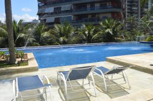 2 sillas y una piscina con palmeras en Next Apartamentos, en Río de Janeiro