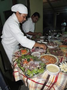 een chef-kok die eten bereidt aan een tafel met groepen voedsel bij Le Pandanus in Rodrigues Island