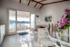 ein Wohnzimmer mit einem Glastisch und einer Blumenvase in der Unterkunft Villa Riva, Vis in Vis