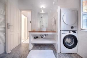 ein weißes Badezimmer mit einer Waschmaschine darin in der Unterkunft Villa Riva, Vis in Vis