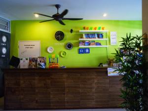 a green wall with a counter and a ceiling fan at VX The Fifty in Bangkok