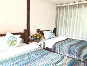 a hotel room with two beds and a window at In Spring Country Courtyard in Lijiang in Lijiang