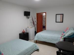 1 dormitorio con 2 camas, mesa y silla en Kings House, en San Andrés