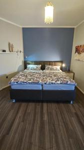 a bedroom with a bed with a blue wall at Ferienwohnung Werraglück in Eschwege