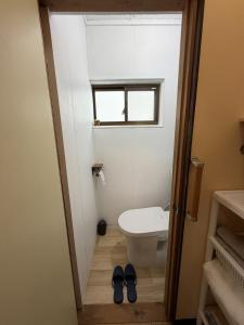 a bathroom with a toilet and two pairs of shoes at Omuta Cozy Stay in Ōmuta +14 photos