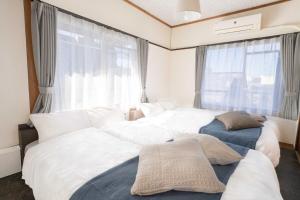 a bedroom with two beds and a window at REKADO ROOM Kengun in Kumamoto