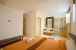 - une chambre avec un grand lit et une douche dans l'établissement Flora Apartment Bali, à Seminyak