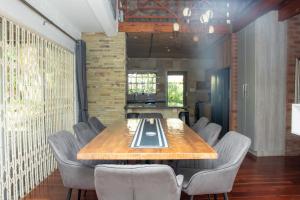 a dining room with a wooden table and chairs at Black n Whyt Villa in Kloof