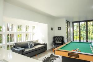 a living room with a pool table and a couch at Black n Whyt Villa in Kloof