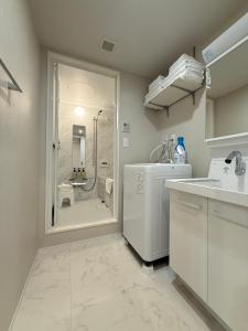 a bathroom with a shower and a sink and a washer at PRISM Inn Ikegami Kamata in Tokyo +95 photos