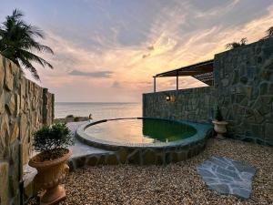 a small pool in the side of a building next to the ocean at Anket De' River Mui Ne resort in Mui Ne