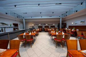 a dining room with tables and chairs in a restaurant at DLRG Tagungszentrum Hotel Delphin in Bad Nenndorf