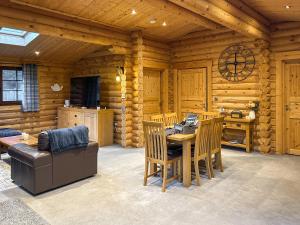a living room with a table and a couch in a log cabin at The Outback - Uk50982 in West Thirston