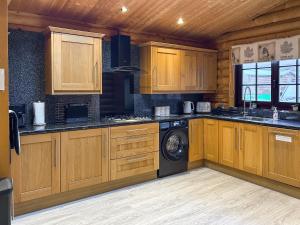 a kitchen with wooden cabinets and a washing machine at The Outback - Uk50982 in West Thirston