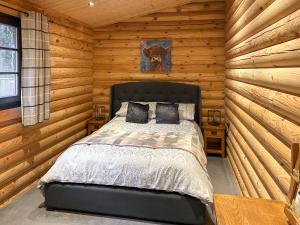 a bedroom with a bed in a log cabin at The Outback - Uk50982 in West Thirston +10 photos