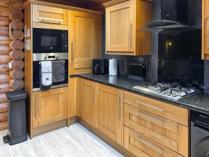 a kitchen with wooden cabinets and a stove top oven at The Outback - Uk50982 in West Thirston