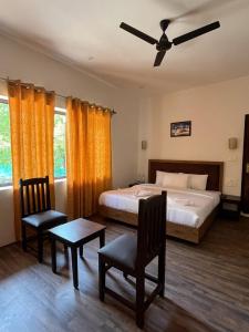 a bedroom with a bed and a ceiling fan at The Walnut House in Pahalgām