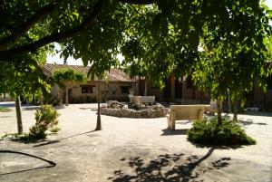 a park with benches and trees in front of a building at Rincon Del Cierzo in Lécera