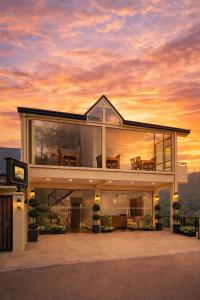 a large house with a sunset in the background at La Cottage in Nuwara Eliya