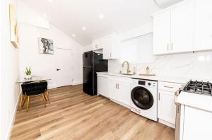 a kitchen with white cabinets and a black refrigerator at Stellar Sherman Oaks One Bedroom close to Universal Studios in Burbank