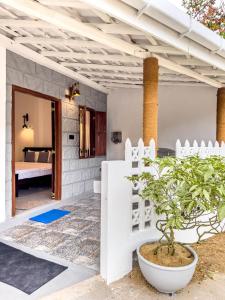 a room with a white fence and a potted plant at Tidal Nest in Weligama