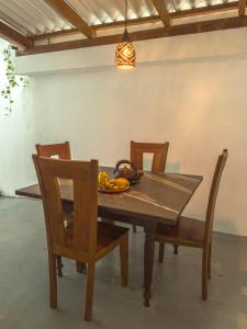 a wooden table with chairs and a bowl of fruit on it at Tidal Nest in Weligama +22 photos