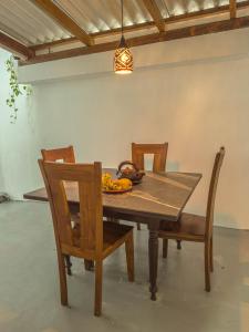 a wooden table with chairs and a bowl of fruit on it at Tidal Nest in Weligama