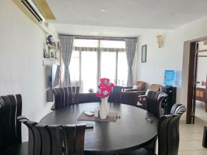 a dining room with a table and chairs with a vase of flowers at Chic two bedroom Beachfront apartment 5th floor in Ukunda