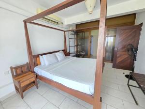 a bedroom with a canopy bed with a wooden frame at Chic two bedroom Beachfront apartment 5th floor in Ukunda