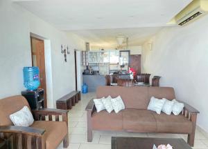 a living room with a couch and chairs and a kitchen at Chic two bedroom Beachfront apartment 5th floor in Ukunda