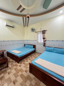 a room with two beds and a table at Nhà nghỉ Phú Mỹ in Ấp An Mỹ +15 photos
