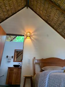 a bedroom with a bed and a light on a wall at Hausatins in Atins